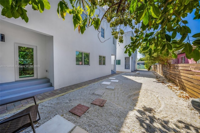 exterior space with stucco siding, a patio, and fence