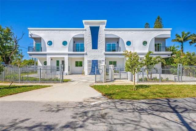 view of front of property featuring a fenced front yard, stucco siding, and a gate