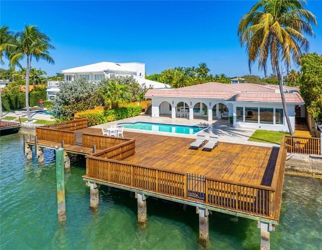 1690 Daytonia Rd, Miami Beach, FL 33141 - rear view of house featuring a water view, a tiled roof, an outdoor pool, and a patio area