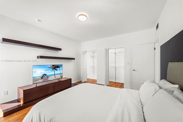 1690 Daytonia Rd, Miami Beach, FL 33141 - bedroom featuring wood finished floors, multiple closets, and baseboards