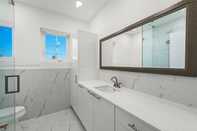 1690 Daytonia Rd, Miami Beach, FL 33141 - full bathroom featuring marble tiled floors, toilet, vanity, a marble finish shower, and tile walls