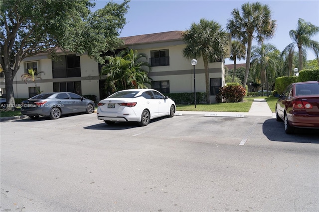 view of front of home with uncovered parking and stucco siding