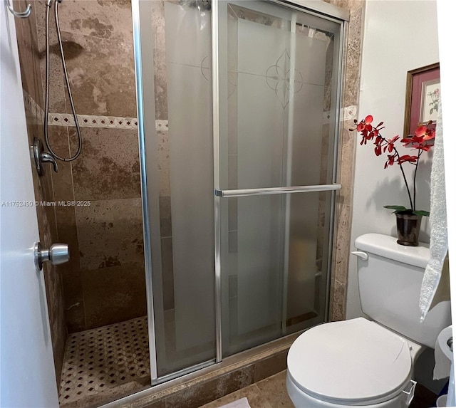 full bathroom featuring a stall shower and toilet