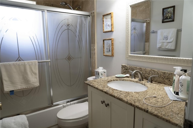 bathroom with toilet, vanity, and bath / shower combo with glass door