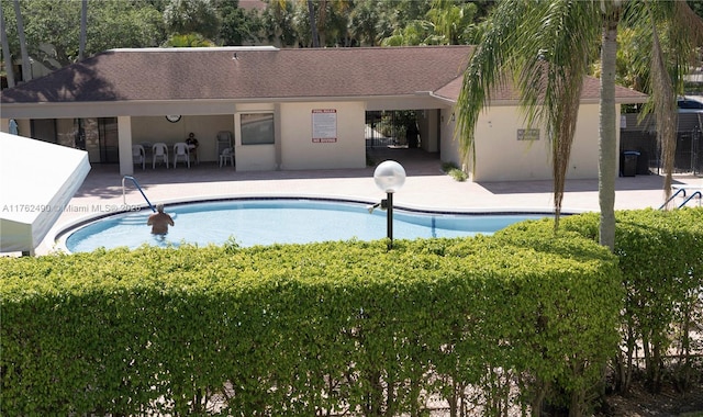 pool with a patio and fence