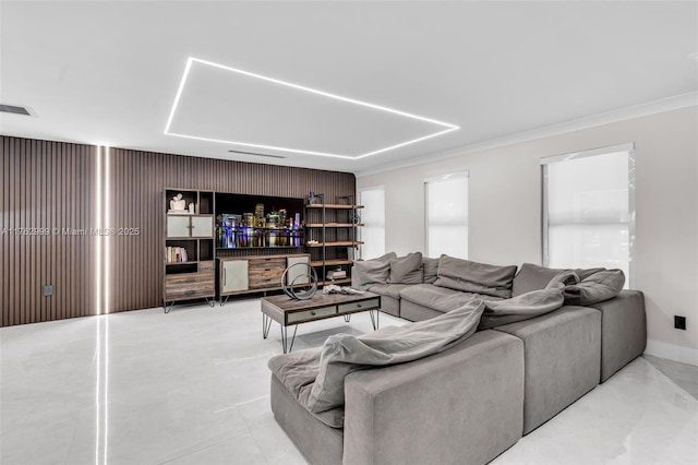 living room featuring baseboards, visible vents, and ornamental molding