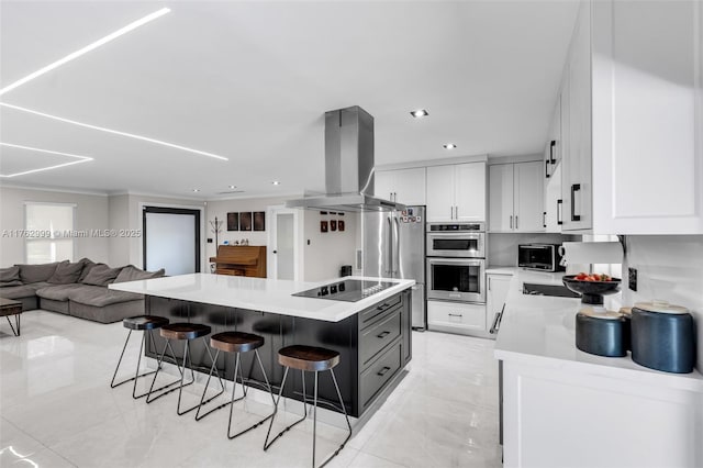 kitchen with a kitchen breakfast bar, double oven, island range hood, light countertops, and black electric stovetop