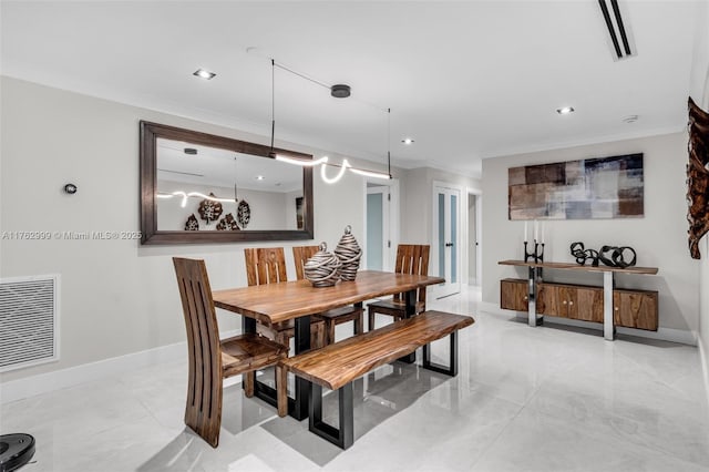 dining room featuring baseboards, visible vents, and ornamental molding