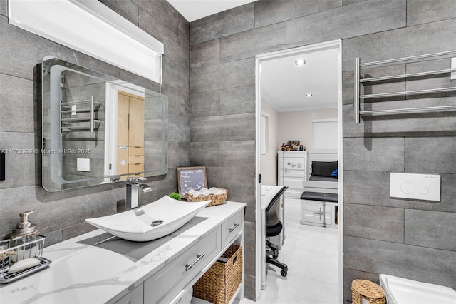 bathroom featuring radiator, tile walls, and vanity