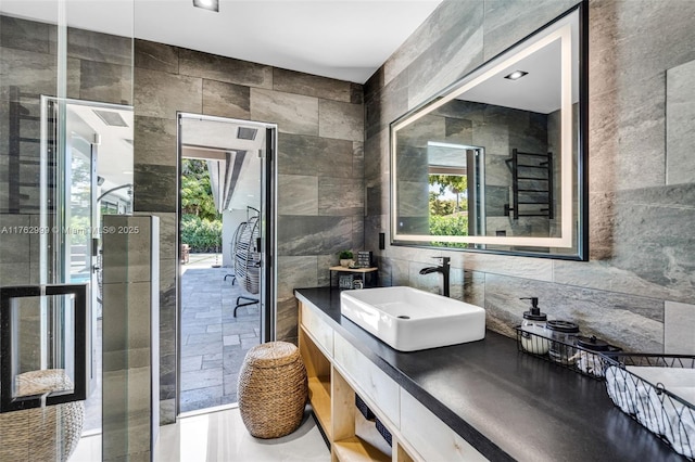 bathroom featuring vanity and tile walls