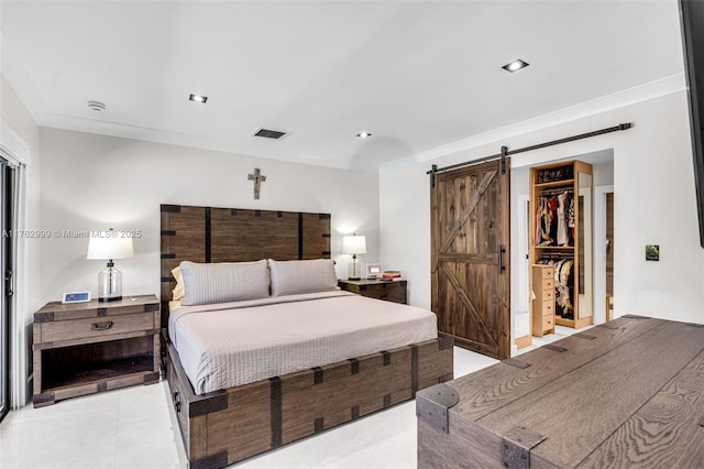 bedroom with light tile patterned floors, visible vents, a spacious closet, crown molding, and a barn door