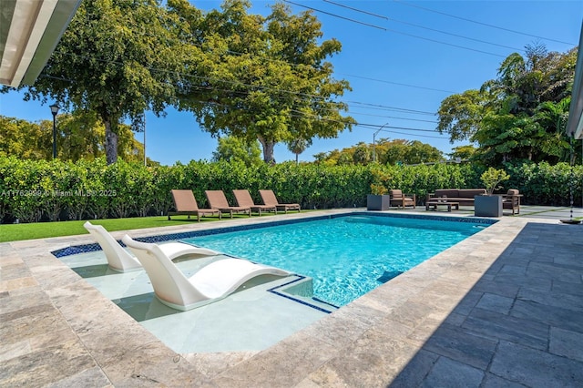 view of pool featuring a patio area, an outdoor living space, and a fenced in pool