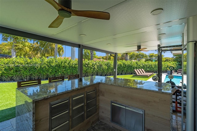 view of patio with outdoor wet bar, a fenced in pool, and ceiling fan