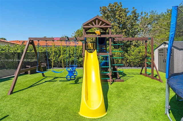 communal playground with a shed, an outdoor structure, a yard, and fence