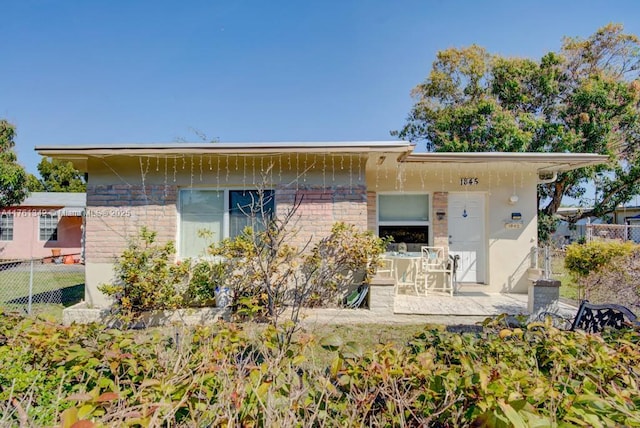 back of property featuring a patio area, brick siding, and fence