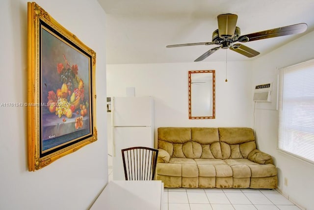 living area with a wall mounted air conditioner, ceiling fan, and light tile patterned floors