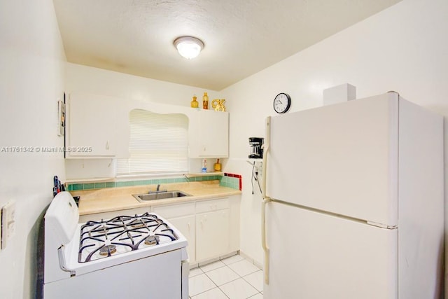 kitchen featuring light countertops, light tile patterned flooring, white appliances, white cabinetry, and a sink