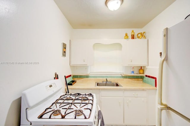 kitchen with white cabinetry, white appliances, light countertops, and a sink