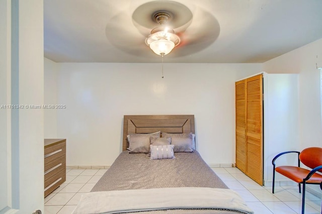 bedroom featuring light tile patterned floors, a closet, and a ceiling fan