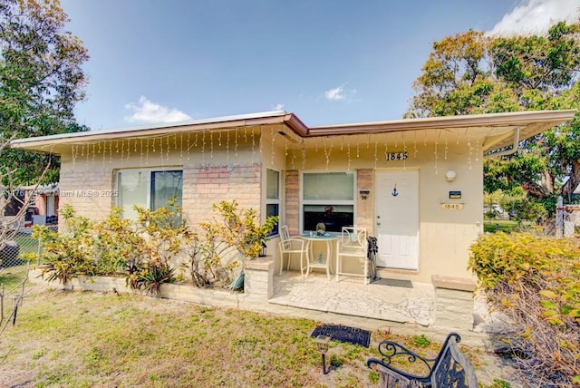 back of house featuring a patio area and brick siding