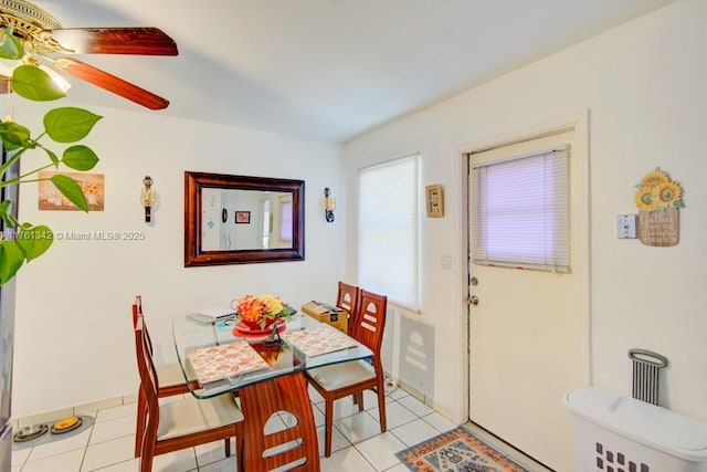 dining room with baseboards, light tile patterned flooring, and a ceiling fan