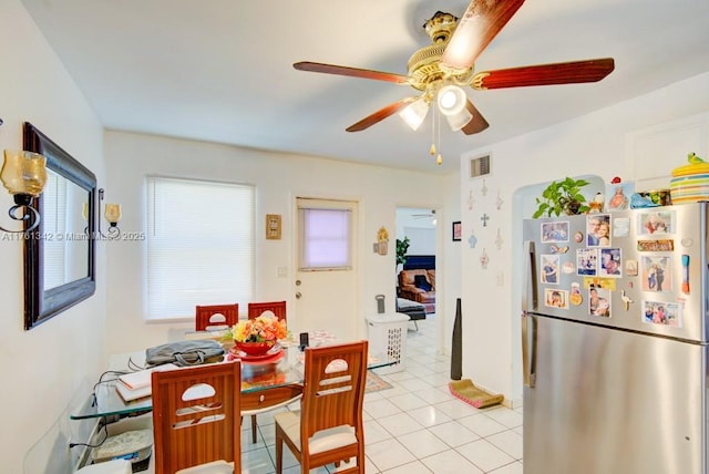 dining area with light tile patterned floors, visible vents, and a ceiling fan