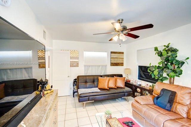 living area with light tile patterned floors, visible vents, a ceiling fan, and a fireplace