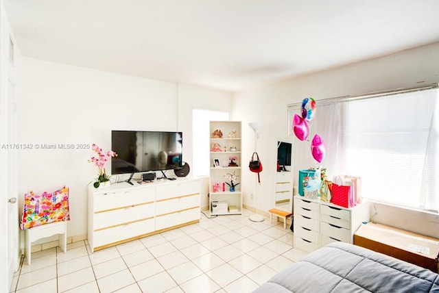 bedroom with light tile patterned floors and baseboards