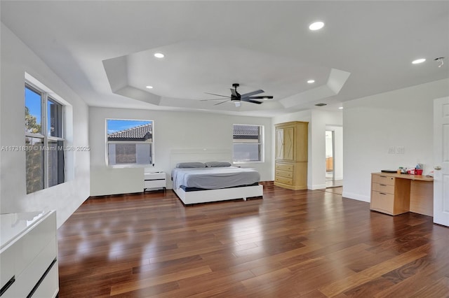 unfurnished bedroom with recessed lighting, baseboards, a raised ceiling, and wood finished floors