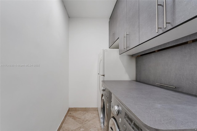 washroom featuring laundry area, washer / clothes dryer, light tile patterned flooring, and baseboards