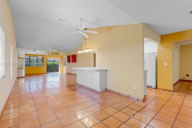 unfurnished living room featuring visible vents, a ceiling fan, a textured ceiling, light tile patterned floors, and baseboards