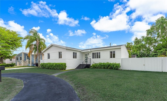 single story home with stucco siding, a front yard, and fence