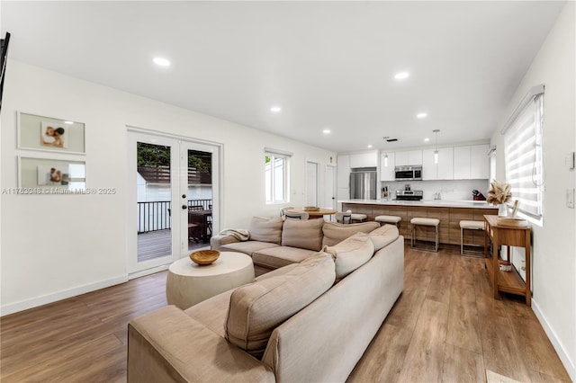 living room featuring recessed lighting, french doors, baseboards, and light wood finished floors