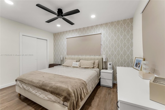 bedroom featuring wallpapered walls, baseboards, recessed lighting, wood finished floors, and a closet