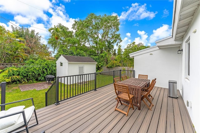 wooden deck featuring an outbuilding, area for grilling, a storage shed, and a yard