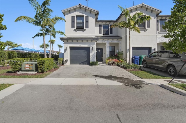 view of front of house with stucco siding, decorative driveway, and an attached garage