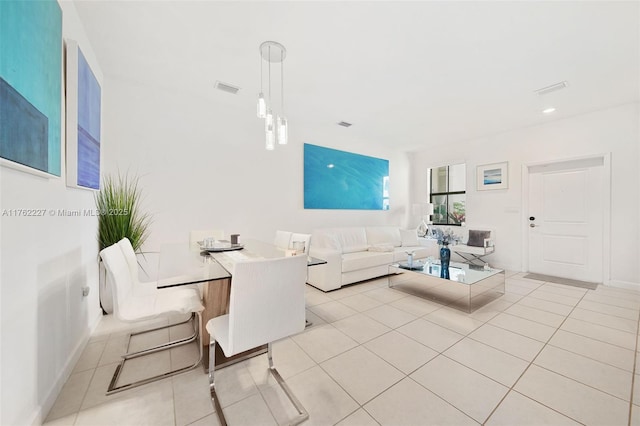 living area with light tile patterned floors, visible vents, and baseboards