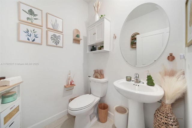 bathroom featuring baseboards, toilet, and tile patterned flooring