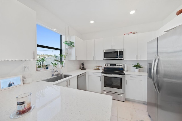 kitchen with light tile patterned floors, recessed lighting, white cabinets, stainless steel appliances, and a sink