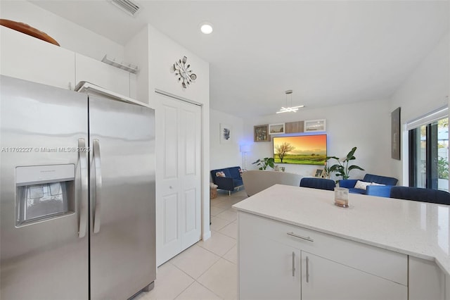 kitchen with visible vents, open floor plan, white cabinetry, stainless steel fridge with ice dispenser, and light tile patterned floors