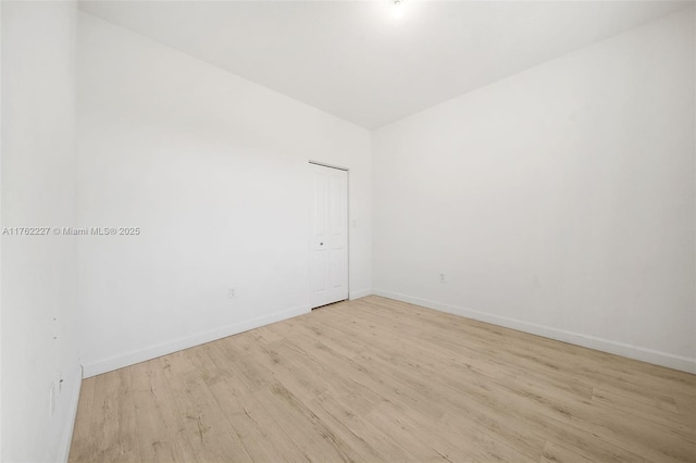 spare room with wood finished floors and baseboards