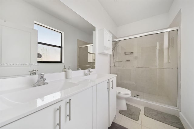 bathroom with a sink, toilet, a shower stall, and tile patterned flooring