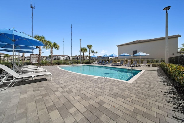 community pool featuring a patio and fence