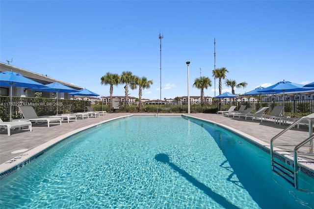 community pool with a patio and fence