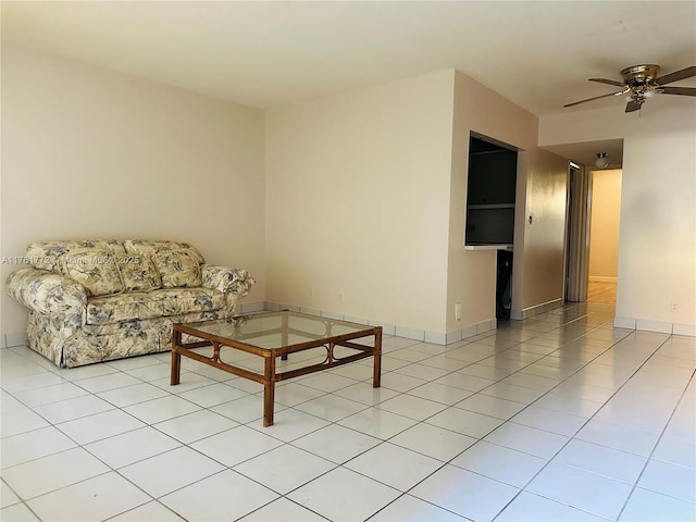 living area with light tile patterned flooring, baseboards, and ceiling fan