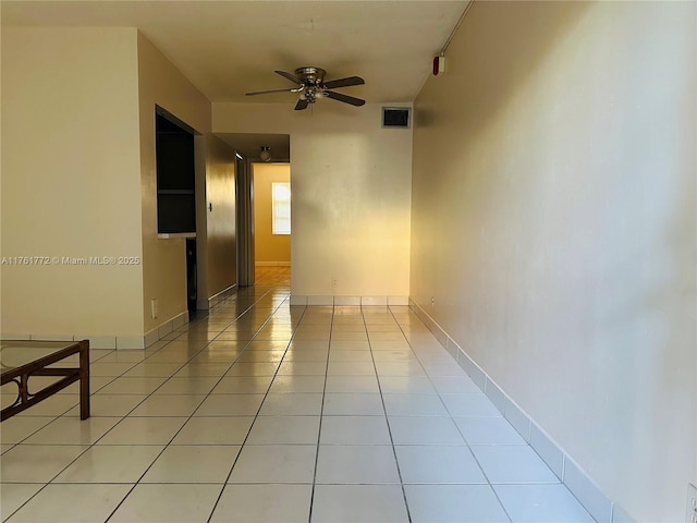 spare room with light tile patterned floors, visible vents, baseboards, and ceiling fan