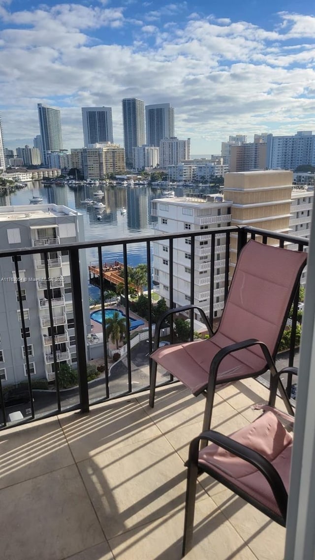 balcony featuring a city view and a water view