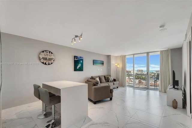 living area with expansive windows and marble finish floor