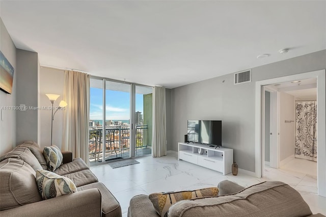 living room featuring visible vents, baseboards, marble finish floor, and expansive windows