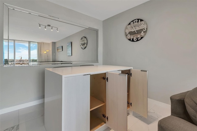 bar with baseboards and marble finish floor